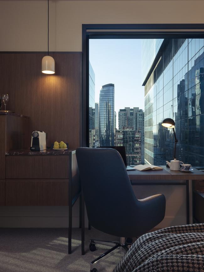 A desk and swivel chair with skyline views.