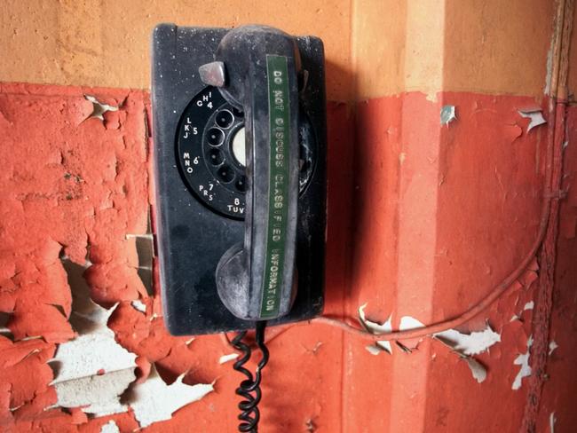 Receiver of old telephone inside missile storage building in Everglades National Park, Florida, USA, reads "Do not discuss classified information".  phone