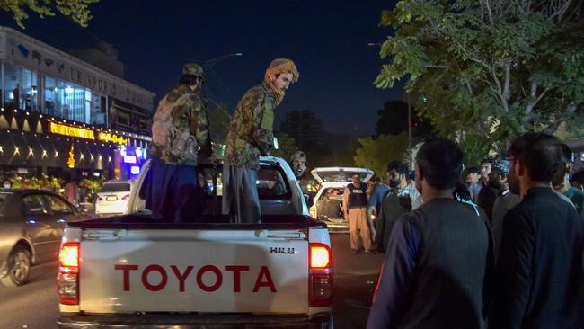 Taliban fighters watch the injured taken to a hospital after the Kabul bombings. The Taliban has condemned the attacks. Picture: AFP