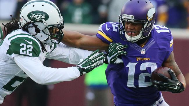 Charles Johnson #12 of the Minnesota Vikings stiff arms Marcus Williams #22 of the New York Jets.