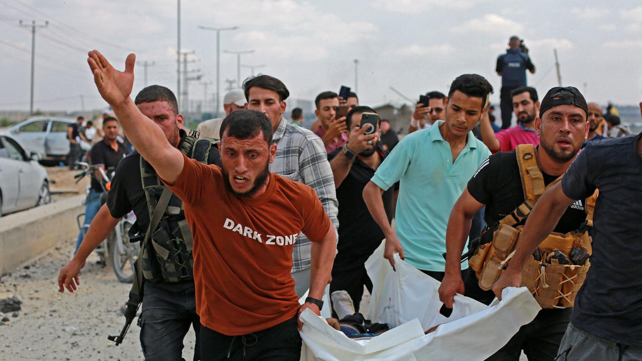 Palestinian militants carry a victim following an Israeli air strike at the Erez crossing between Israel and the northern Gaza Strip. Picture: AFP