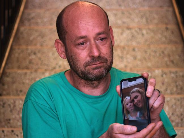 Mick Fairfield holds a photo of his family after his wife was allegedly murdered in their driveway. Picture: (A)manda Parkinson