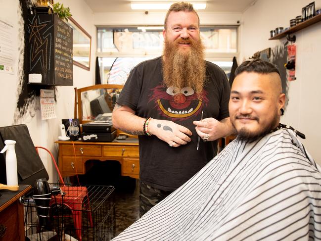 Barber Steff Gil with client Ellis Lei in the main street of Cessnock. Labor has been elected in the seat of Hunter since 1910. Picture: Ryan Osland