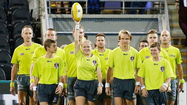 NOW RECRUITING: Holding the ball aloft like the Holy Grail, these AFL Community Umpires umpired are part of a close-knit team without whom we would have no grass-roots Aussie rules. Photo courtesy Michael Willson/AFL Media