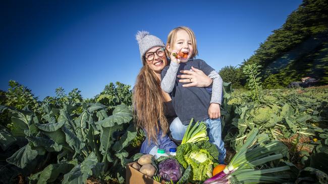 Project co-ordinator of the Bream Creek Community Market Garden Rebecca Kelley with son, Frank Mausz, 4 with heaps of local produce from their community initiative. Picture: LUKE BOWDEN