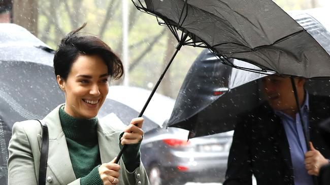 Sarah Budge’s usual steely demeanour turned to laughter when her umbrella flew up as she arrived at her Sydney gun possession trial. Picture: AAP