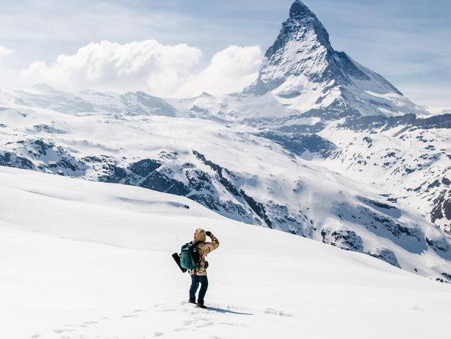 A man walking in the snow looking at the background of Matterhorn, Switzerland.Photo - istockEscape 21 August 2022take a hike