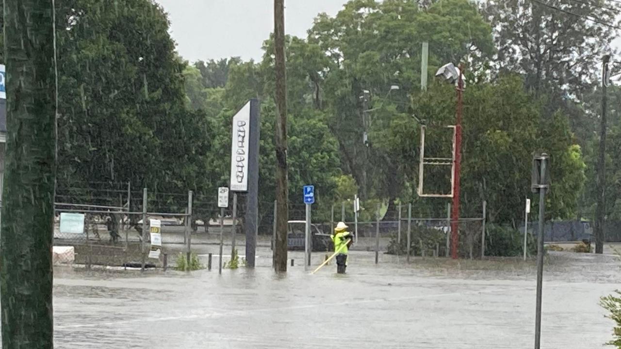 Crews work in the rising floodwaters in the Gympie CBD.