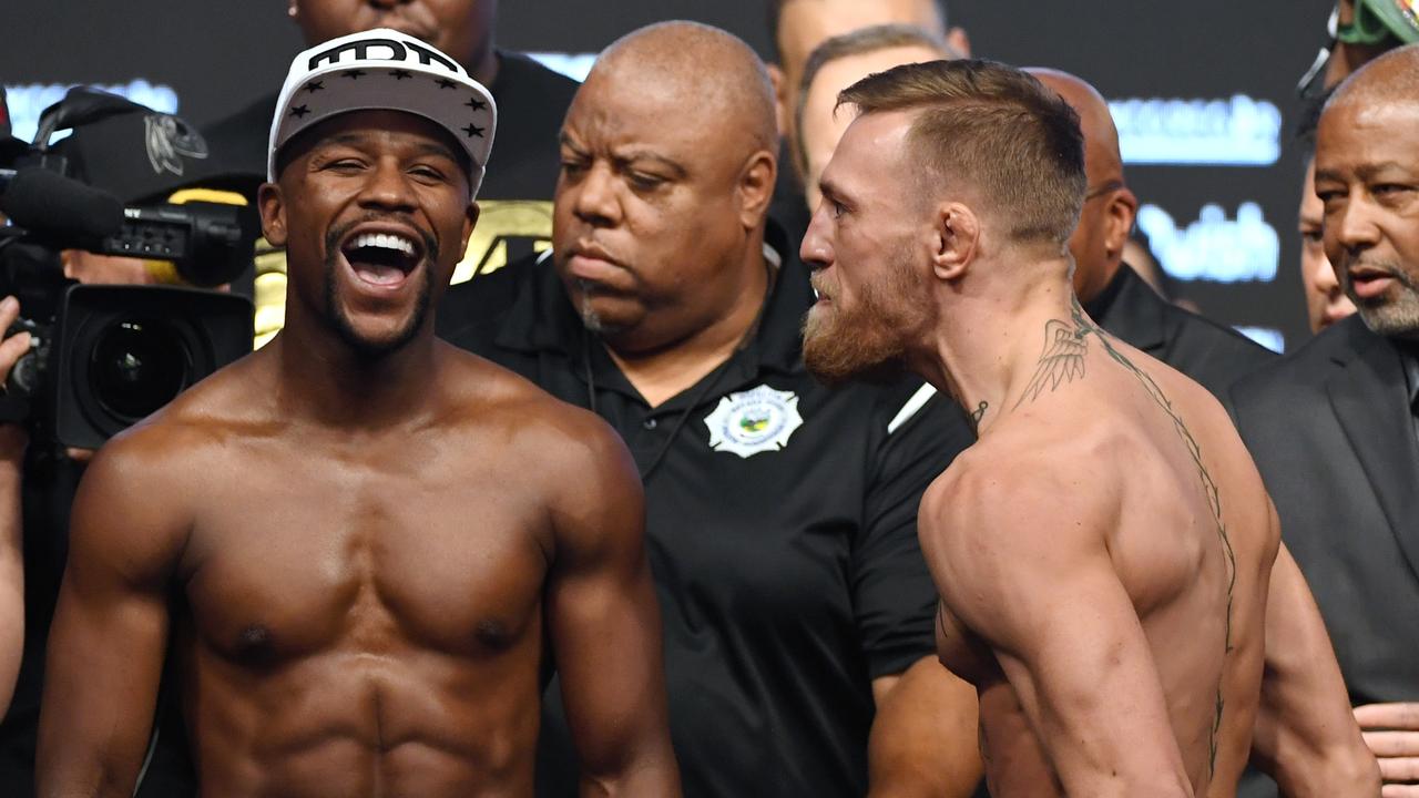 Floyd Mayweather Jr. (L) laughs after facing off with Conor McGregor.