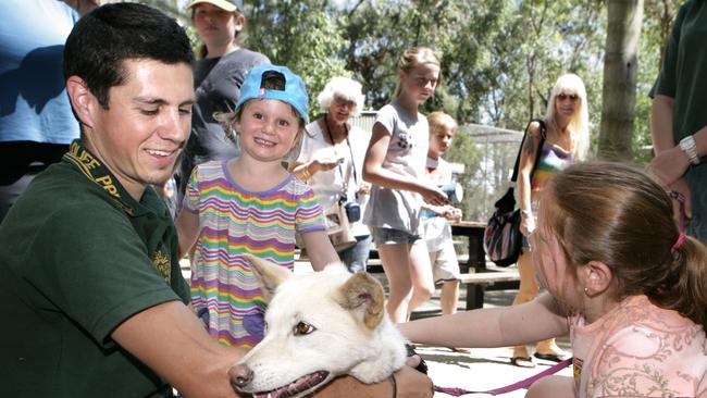 School holiday activities with children at Featherdale Wildlife Park. Daniel Bewley from Featherdale, Ruby Fibbens, 4, patting a dingo.