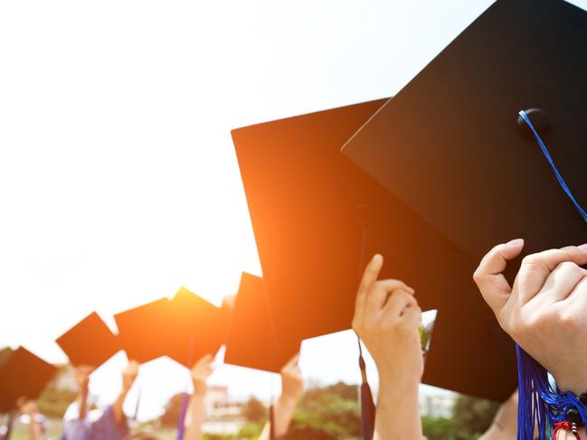 Group of graduate students holding their graduation hats.