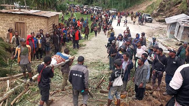 Locals carrying a person on a stretcher from the site of a landslide at Yambali Village in the region of Maip Mulitaka, in Papua New Guinea's Enga Province. Picture: AFP