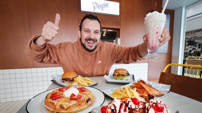 Southport has become home to the return of an iconic Australian milk bar that once dominated suburban corners and small-town streets. PopÃ¢â&#130;¬â&#132;¢s will serve up a nostalgia hit for locals,complete with standup arcade machines, bold red and blue branding finished with retro-styling. Owner Jem Jacinto and a menu sample. Picture Glenn Hampson