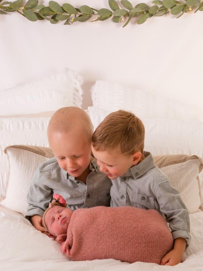 Mason, 4, and his brother Lincoln, 3, hold their baby sister Hazel. Photo: Supplied.