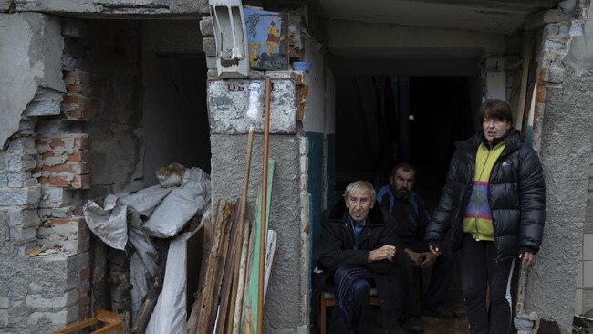 Ukrainian civilians at the entrance to their ruined apartment building in Izyum. Picture: Evgeniy Maloletka/AP/The Times