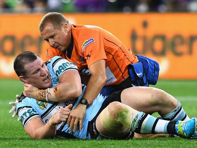 Paul Gallen receives some treatment from the trainer and Melbourne players.