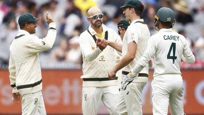 MELBOURNE, AUSTRALIA - DECEMBER 29: Nathan Lyon of Australia (C) celebrates with Pat Cummins of Australia after combining to dismiss Kagiso Rabada of South Africa during day four of the Second Test match in the series between Australia and South Africa at Melbourne Cricket Ground on December 29, 2022 in Melbourne, Australia. (Photo by Daniel Pockett/Getty Images)