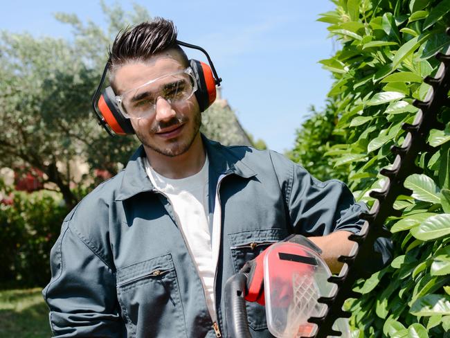 CAREERS: One side hustle is no longer enough to make ends meet, with a growing number of Australians requiring several income streams to pay their mortgage and put food on the table.  Young man gardener trimming hedge. Picture: iStock