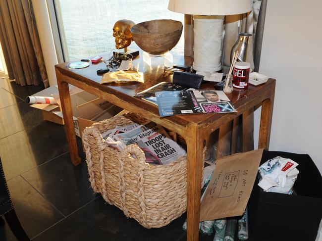 A lamp table in one of John Ibrahim’s rooms with a copy of his autobiography and newspaper including The Sunday Telegraph.