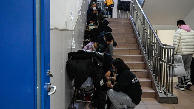 Children receive a drip on the stairs of a Beijing children’s hospital, also on November 23, 2023. Picture: AFP