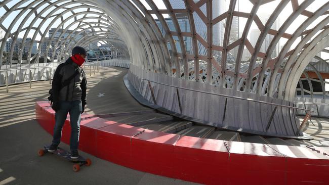 A lone skateboarder crosses Webb Bridge in Melbourne on Monday. Picture: David Crosling