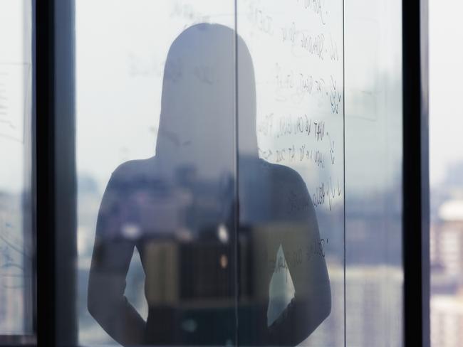 Silhouette shadow of woman looking at city from office