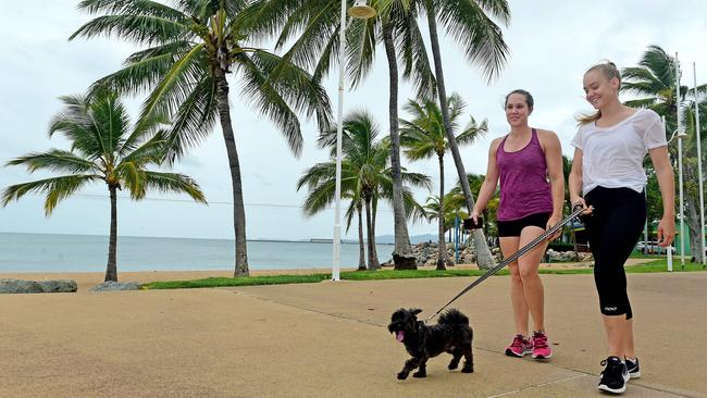 Strand Cyclone Debbie day. Sisters, (L) Hannah Kaesehagen 27yo of Melbourne and  Sophie Kaesehagen 19yo of Belgian Gardens walk with 'Digby' along the Strand.