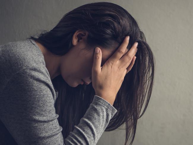 Depressed woman sitting on a chair in dark room at home. Lonly , sad, emotion concept.