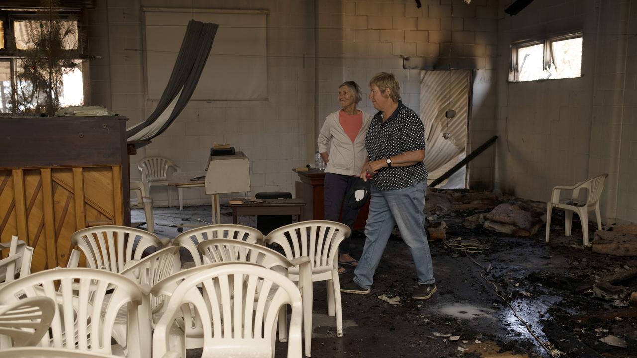 Kate Stanton and Helen Wurst inspect damage to the interior of the hall. Picture: AAP /Emma Brasier