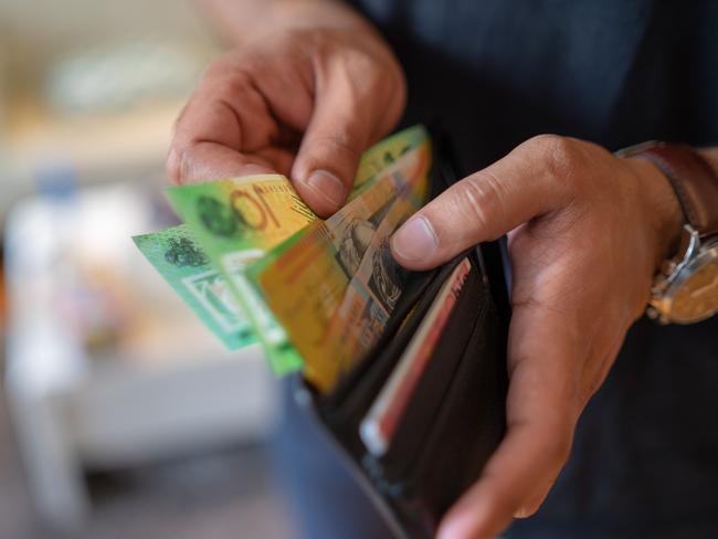 a male taking money out of a wallet, Australian cash generic spending