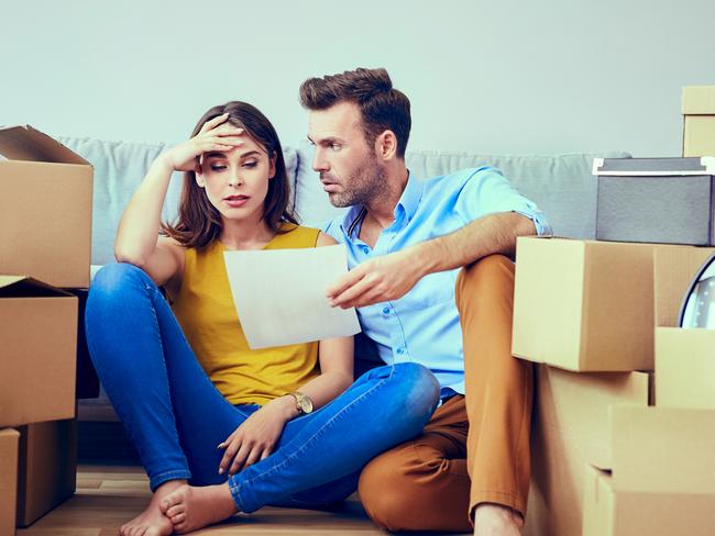 Worried couple reading agreement after moving to new home