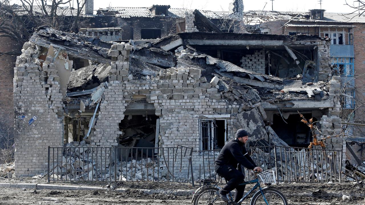A resident rides a bike past a building destroyed during the Ukraine-Russia conflict in the separatist-controlled town of Volnovakha in the Donetsk region. Picture: Reuters/Alexander Ermochenko