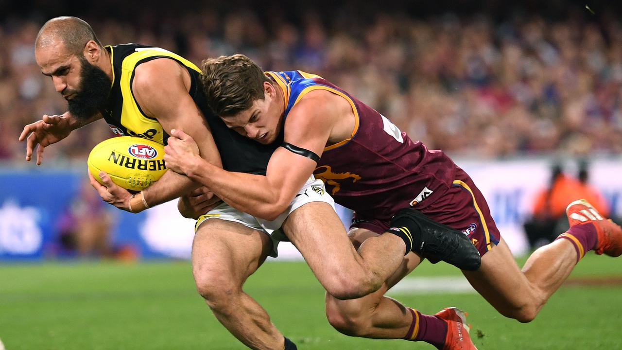 Jarrod Berry lays a tackle on Richmond’s Bachar Houli. Picture: AAP Image/Dave Hunt