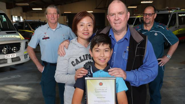 Eleven year old Maxwell Potter with his certificate of appreciation and proud parents Jessie Ying Jie Zhao and Leslie Potter, together with paramedics ralph Wilkinson (left) and Paul Neilsen (right) at Southport Ambulance Station. Leslie Potter suffered a life-threatening onset of asthma at his Runaway Bay home and was left in severe respiratory distress and unable to communicate. Leslie’s son Max recognised the emergency and called Triple Zero . Picture Glenn Hampson