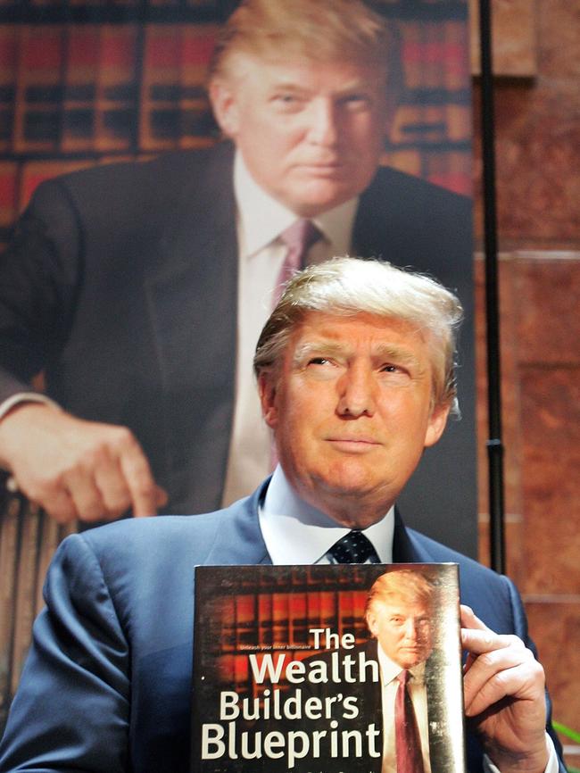 Donald Trump holds The Wealth Builders Blueprint during a press conference announcement of online Trump University in 2005. Picture: AFP