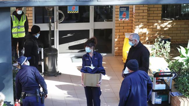 Police, security and NSW Health officers at the entrance to a locked down Bondi apartment building. Picture: John Grainger