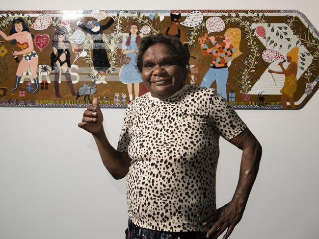 Of the painting, Whiskey said: “Now that I’m an artist myself, I like to say that my artworks are ‘from the comic to the canvas’ because I love to paint my favourite comic book superheroes, especially Wonder Woman. I paint ladies with superpowers because the ladies at Iwantja Arts, where I work, are kungka kunpu (strong women) too! I also love to paint my favourite musicians like Dolly Parton and Tina Turner. I show everyone coming together on Aṉangu Country, sharing bush tucker like tjala (honey ants) and ngiṉtaka (perentie lizard), and having fun, singing and dancing together.” Photo: Merinda Campbell / MAGNT
