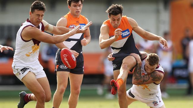 Josh Kelly gets a kick away under pressure from Mitch Robinson.