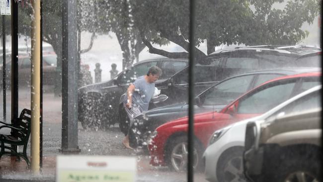 Victoria is bracing for a deluge. A woman crosses the street in Euroa during heavy rain. Picture: Alex Coppel