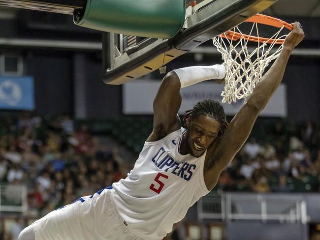 Clippers forward Montrezl Harrell swings from the basket after dunking against the Kings.