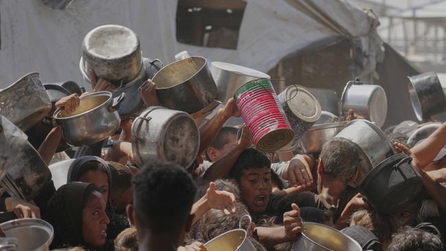 Palestinians struggle to obtain donated food at a community kitchen in Khan Youni. Picture: AP /Abdel Kareem Hana