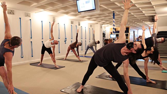 James Hasemer (left) teaching a yoga class where everyone is wearing a mask at Central Yoga School in Surry Hills. Picture: Adam Yip