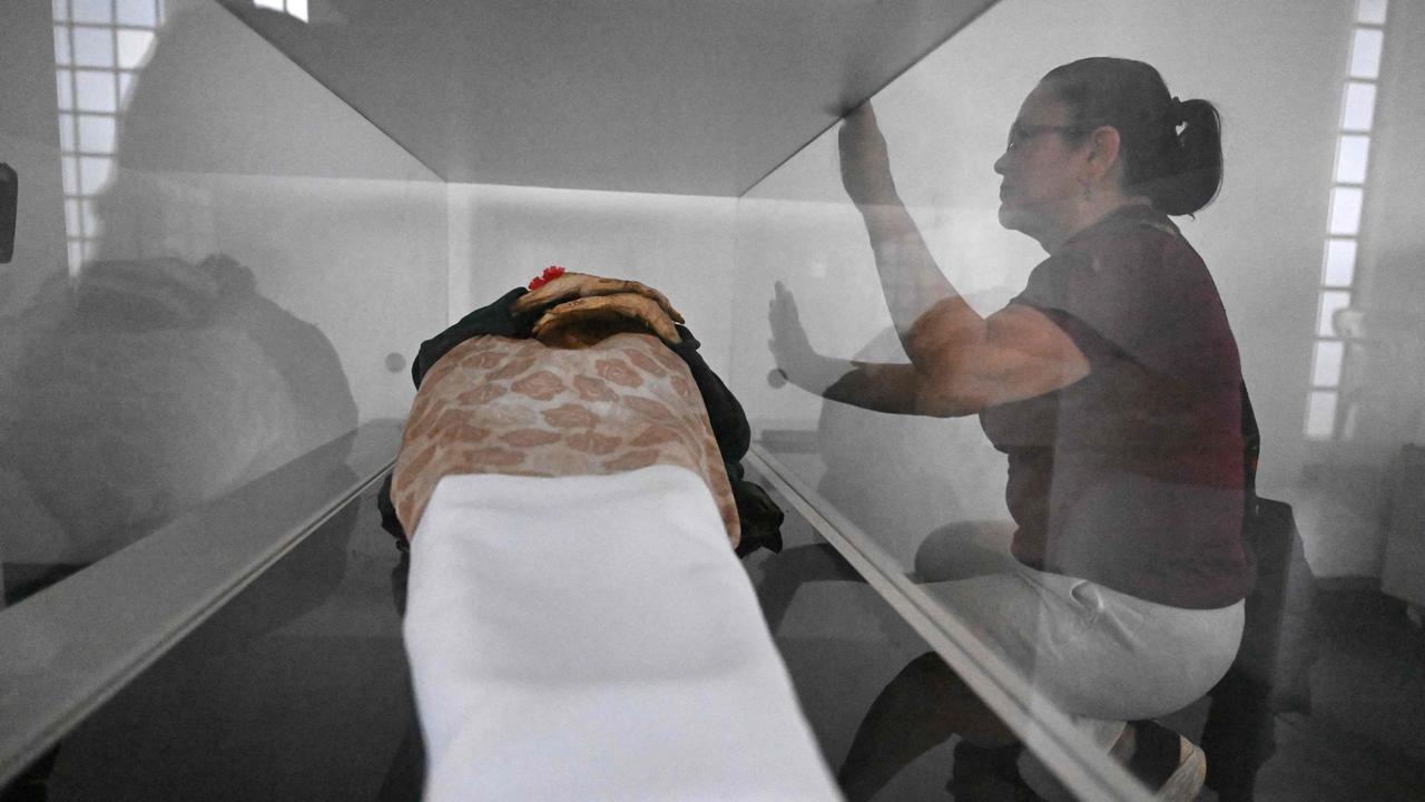 Local resident Clovisnerys Bejarano visits her mother Saturnina Torres, who died in 1993 and was exhumed in 2001, and now rests in the museum of mummies at the Jose Arquimedes Castro mausoleum. Picture: Raul Arboleda / AFP