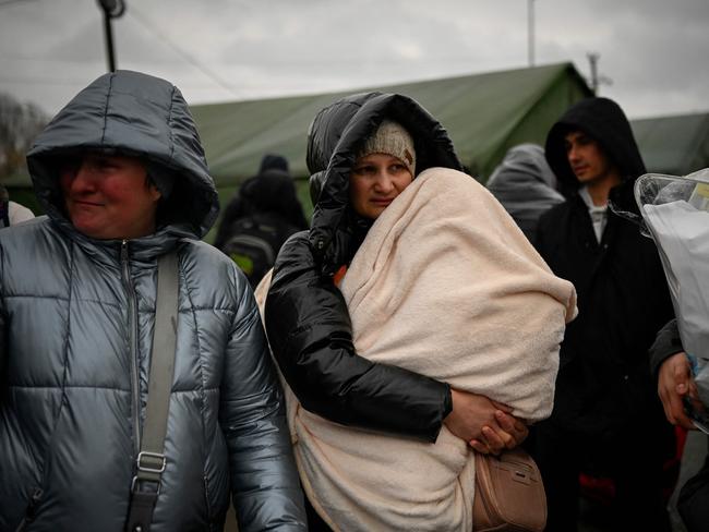 A woman holds a child as refugees from Ukraine wait for a transport at the Moldova-Ukrainian border's checkpoint near the town of Palanca. Picture: AFP