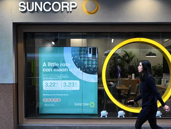 A pedestrian walks past a Suncorp Bank branch in Melbourne on July 18, 2022. - Australian banking giant ANZ announced on July 18 a 3.3 billion USD deal to swallow regional lender Suncorp Bank -- one of the biggest takeovers in the sector for more than a decade. (Photo by William WEST / AFP)