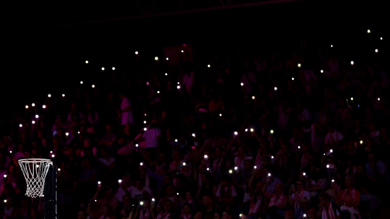 Fans hold torches as a power cut affects parts of the stadium during the match between the Thunderbirds and the Swifts. (Photo by Graham Denholm/Getty Images)