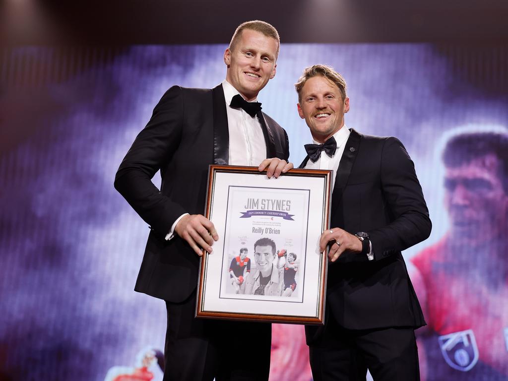 Rory Sloane presents Reilly O'Brien the Jim Stynes Community Award. Picture: Dylan Burns/AFL Photos via Getty Images.