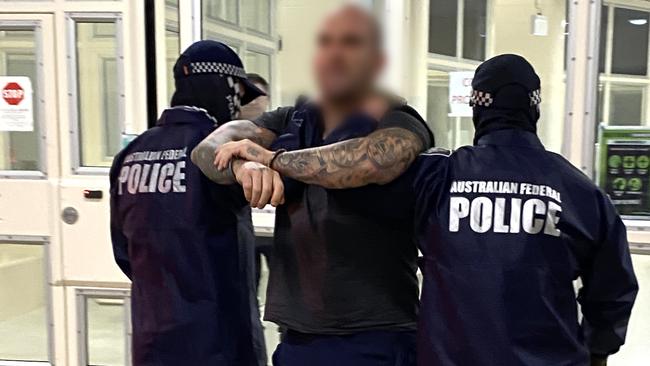 AFP officers escort Mark Buddle. Picture: Australian Federal Police