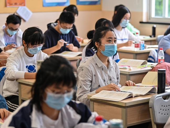 Students in China wear face masks to protect them against COVID-19, which spread rapidly across the globe. Picture: AFP