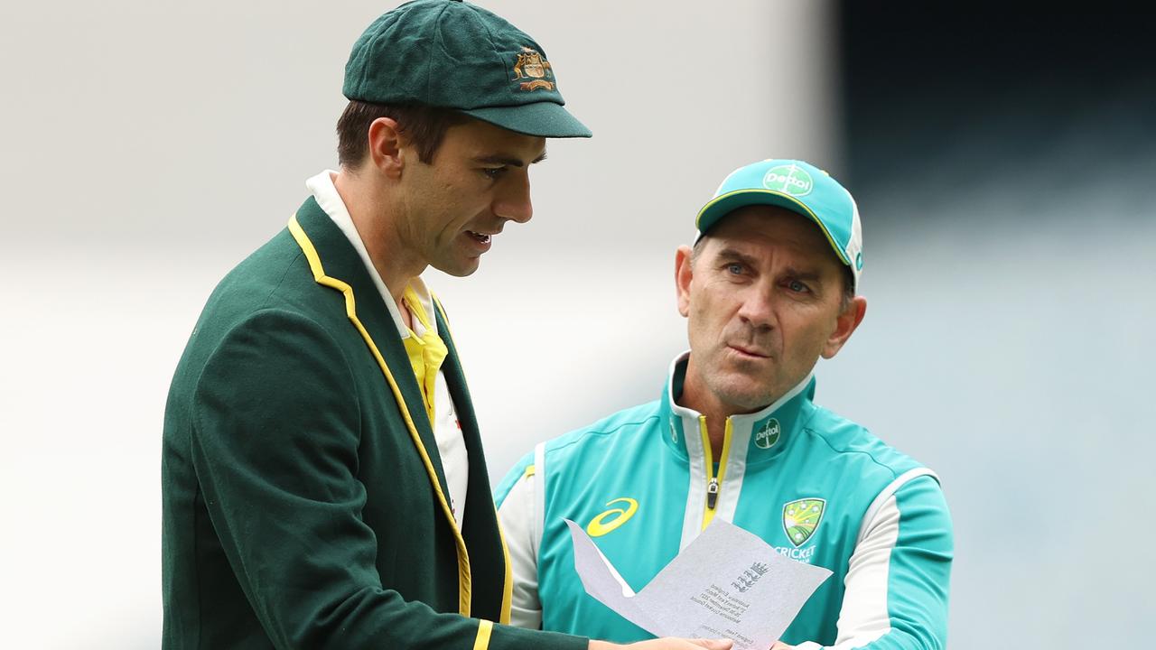 MELBOURNE, AUSTRALIA - DECEMBER 26: Pat Cummins of Australia and Australia head coach Justin Langer are seen with England's team list during day one of the Third Test match in the Ashes series between Australia and England at Melbourne Cricket Ground on December 26, 2021 in Melbourne, Australia. (Photo by Robert Cianflone/Getty Images)